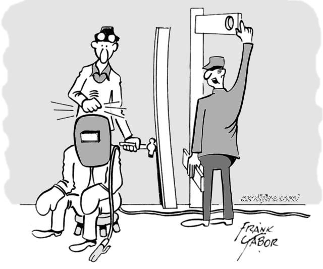 Three welders, one knocking on sitting helmeted welder's helmet the other saying. . .